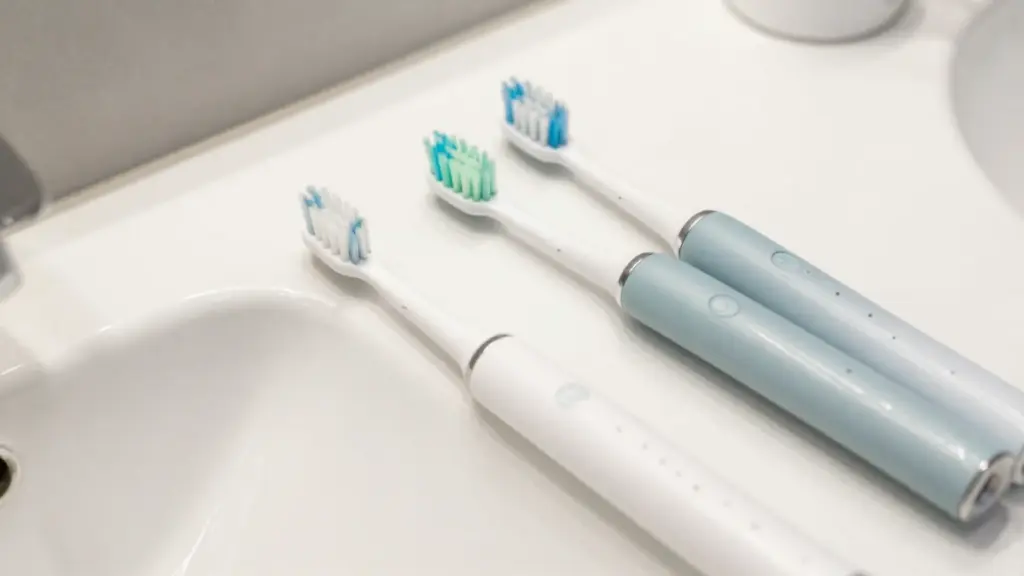 Person using electric toothbrush with pressure sensor light